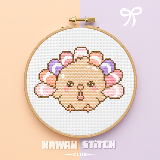 Finished pastel turkey cross stitch pattern displayed in a wooden hoop