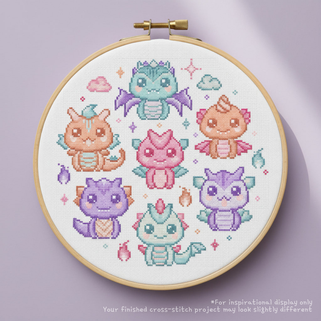 Finished pastel baby dragons cross stitch displayed in a wooden hoop