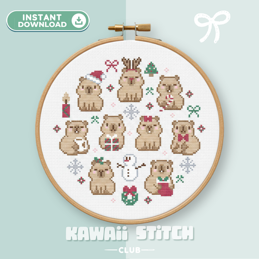 Christmas capybara cross stitch pattern in a hoop with nine festive capybaras, a snowman, gifts and a wreath
